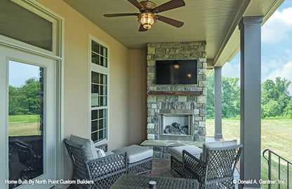 Stone outdoor fireplace on the rear covered porch. The Foxglove plan 1297.