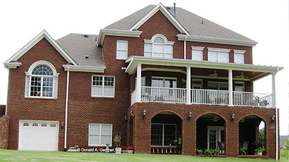 rear walkout basement with arched brick openings and relaxing covered porch above