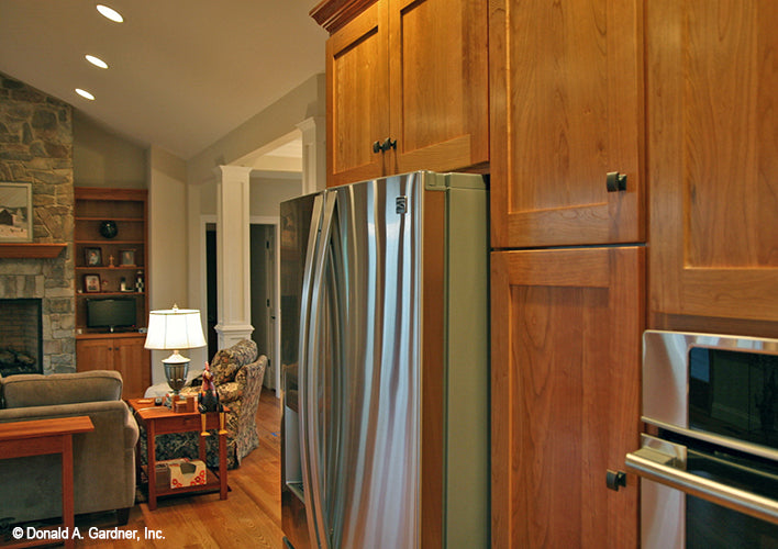 Brown cabinets in the kitchen. The Hammond Hill plan 1217.