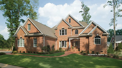 metal roof caps the front porch of this two-story brick house with lots of arched windows