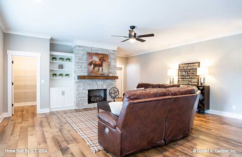 Stone fireplace and built in shelves in the entertainment room. The Hollowcrest plan 5019.