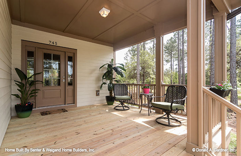 Covered front porch with seating area off to the side of the front door. The Jarrell plan 1017.