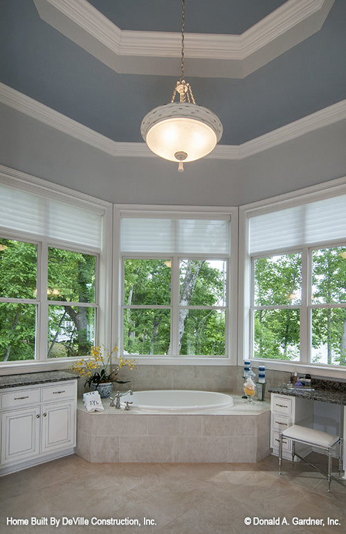 Sitting tub surrounded by windows in the master bathroom. The Jasper Hill plan 5020.