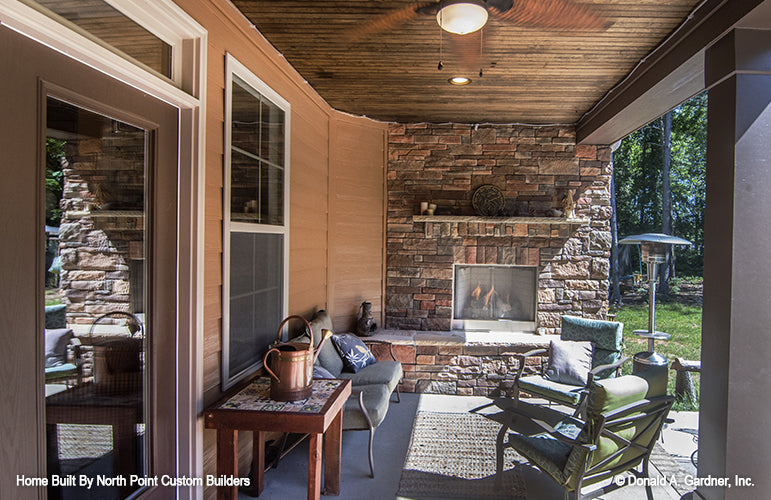 Rear covered porch with an outdoor fireplace. The Lisenby plan #1220.