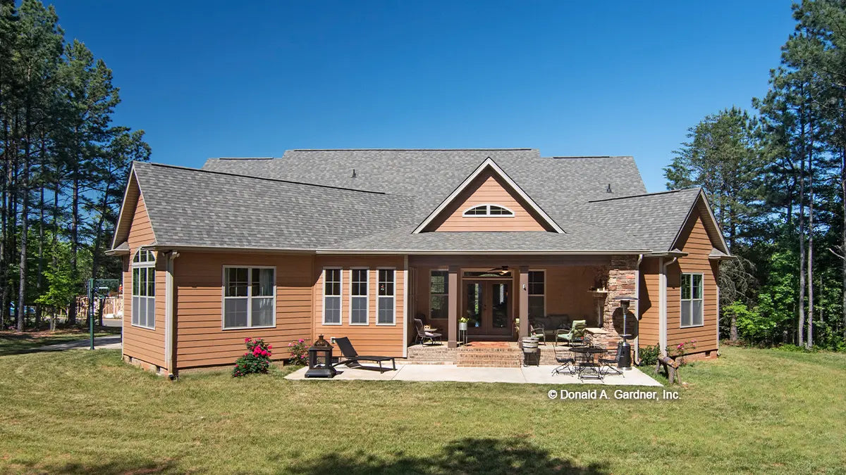 Rear view photograph with a covered porch. The Lisenby plan #1220.