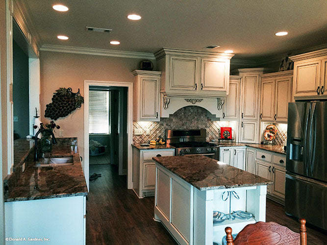 Kitchen picture showing open layout and island for house plan 1319 The Lucerne