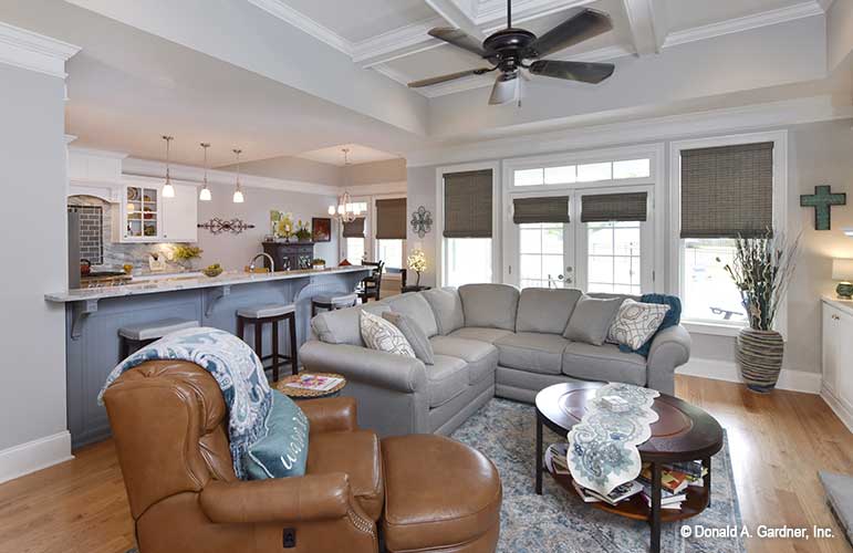 View of the great room with coffered ceilings, alongside the kitchen bar seating.  The Lucy plan 1415