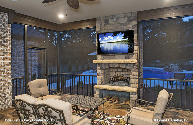 Stone fireplace and tv in the screened in porch. The MacAllaster plan 838. 