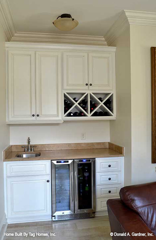 White cabinets and a sink at the wet bar. The Merrill plan 1209