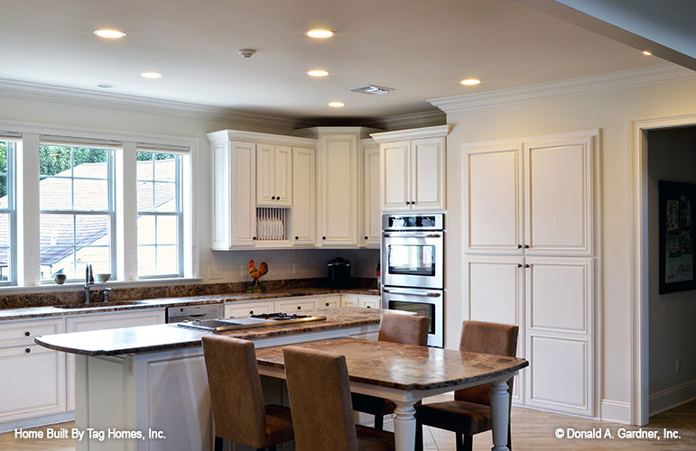 White cabinets and recessed lighting in the kitchen. The Merrill plan 1209