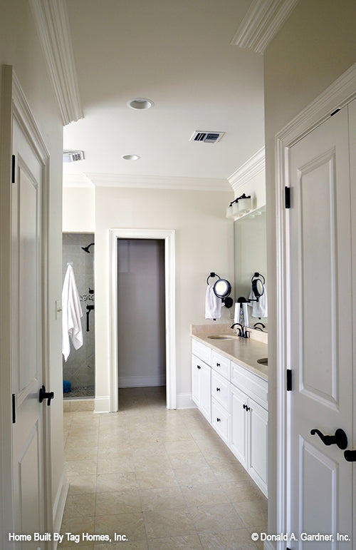 Isle view into the master bathroom with recessed ceiling lighting. The Merrill plan 1209