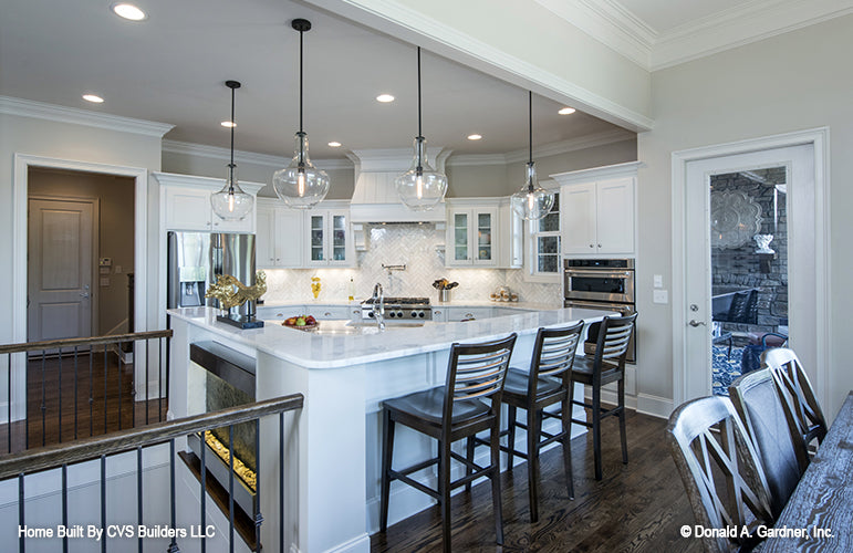 Bar seating at the island in the kitchen. The Monarch Manor plan 5040.