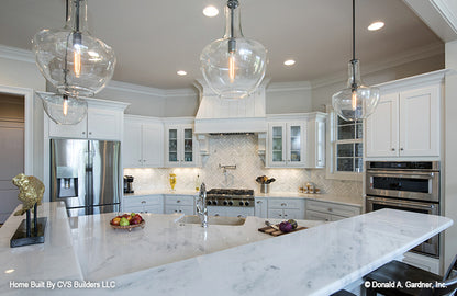 Hanging pendant lighting with glass globes in the kitchen. The Monarch Manor plan 5040.