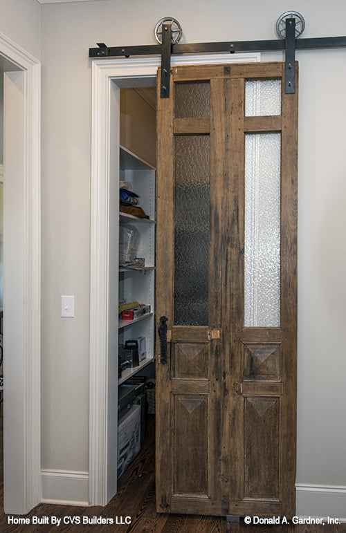 Sliding farmhouse style door to the pantry. The Monarch Manor plan 5040.