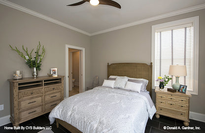 Crown molding along the ceiling and ceiling fan in the bedroom. The Monarch Manor plan 5040.