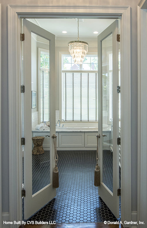 French glass doors open to the master bathroom. The Monarch Manor plan 5040.