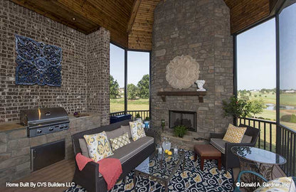 Floor to ceiling stone fireplace in the screened in porch. The Monarch Manor plan 5040.