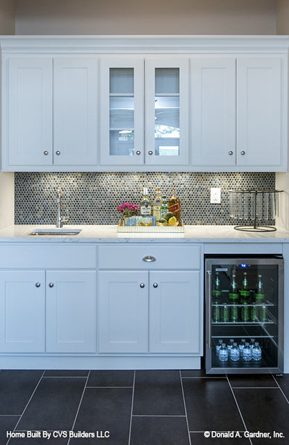 Tiled backsplash and white cabinets in the wet bar. The Monarch Manor plan 5040.