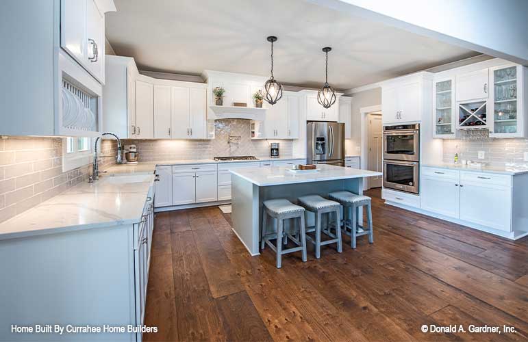 White cabinets and wood floors in the kitchen. The Nicholette plan 1520.