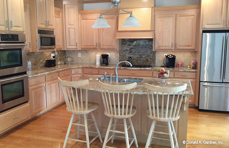 Island with seating and a sink in the kitchen. The Oakmont plan 318.