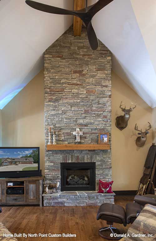 Rustic fireplace and center point of great room in stone for plan 1427 The Oliver