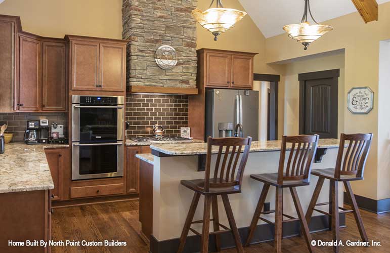 Eye catching bar counter with seating in kitchen for plan 1427 The Oliver