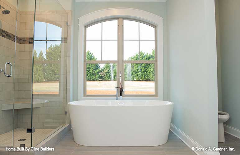 Master bath features views of nature and a large shower tub area with toilet room for plan 1428 The Oscar