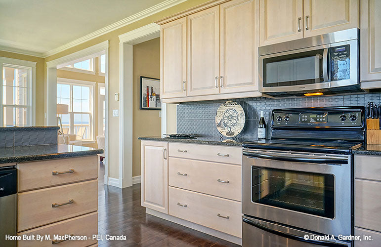 Wood cabinets and tiled backsplash in the kitchen. The Palm Lily plan 845. 