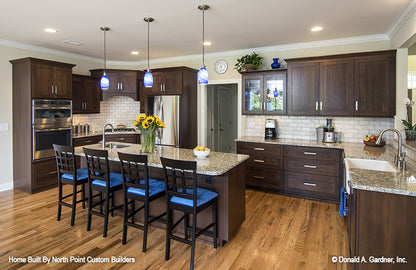 Dark brown cabinets and white subway tiles in the kitchen. The Peyton plan 1289.