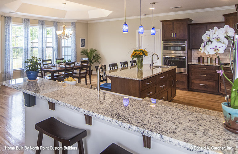 Seating at the bar height ledge in the kitchen. The Peyton plan 1289.