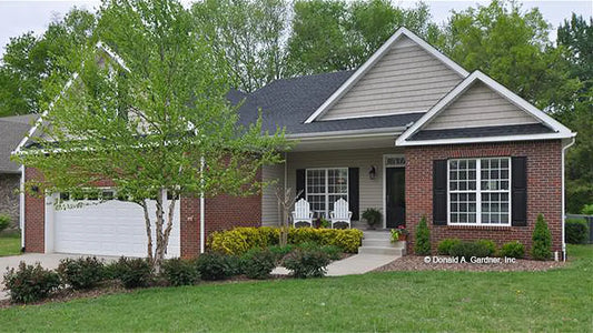 Front view photograph with a two-car garage and brick facing. The Pinebluff plan 1036.