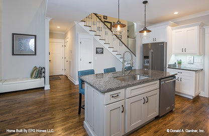 This is a picture of the kitchen showing island and pantry of simple house plan 1108 The Radford