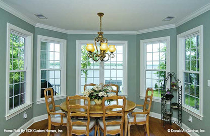 Well-lit dining room with crown molding ceiling. The Rowan plan 1366. 