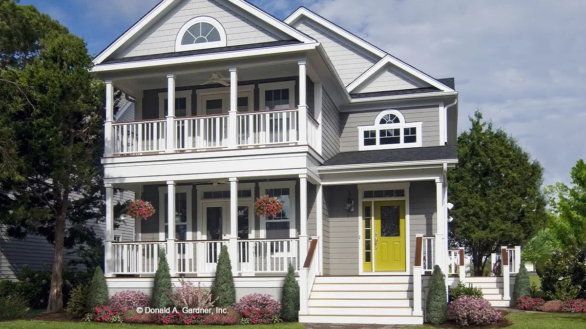 Photographs submitted by the customer. Front view of a narrow home with second level porch. The Sassafras plan 814.