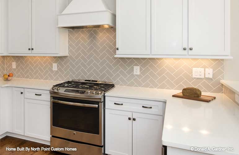 All white cabinets in the kitchen with Harring bow backsplash. The Satchwell plan 967