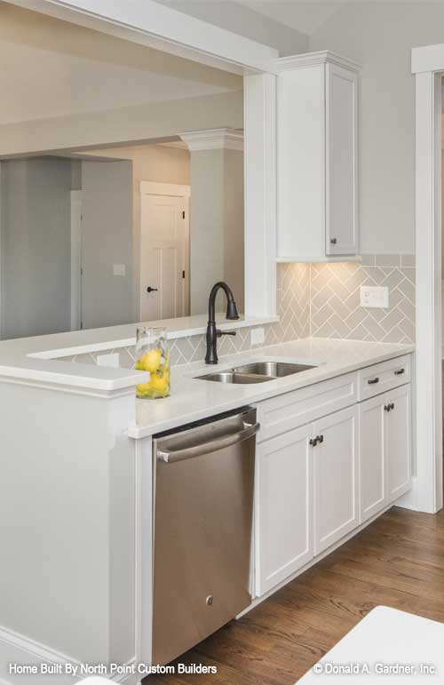 Sink view of the kitchen with bar seating overlooking. The Satchwell plan 967