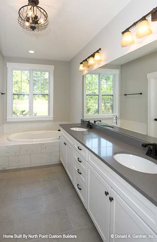 Lots of counter space with double sink vanity beside the sitting tub with window above. The Satchwell plan 967