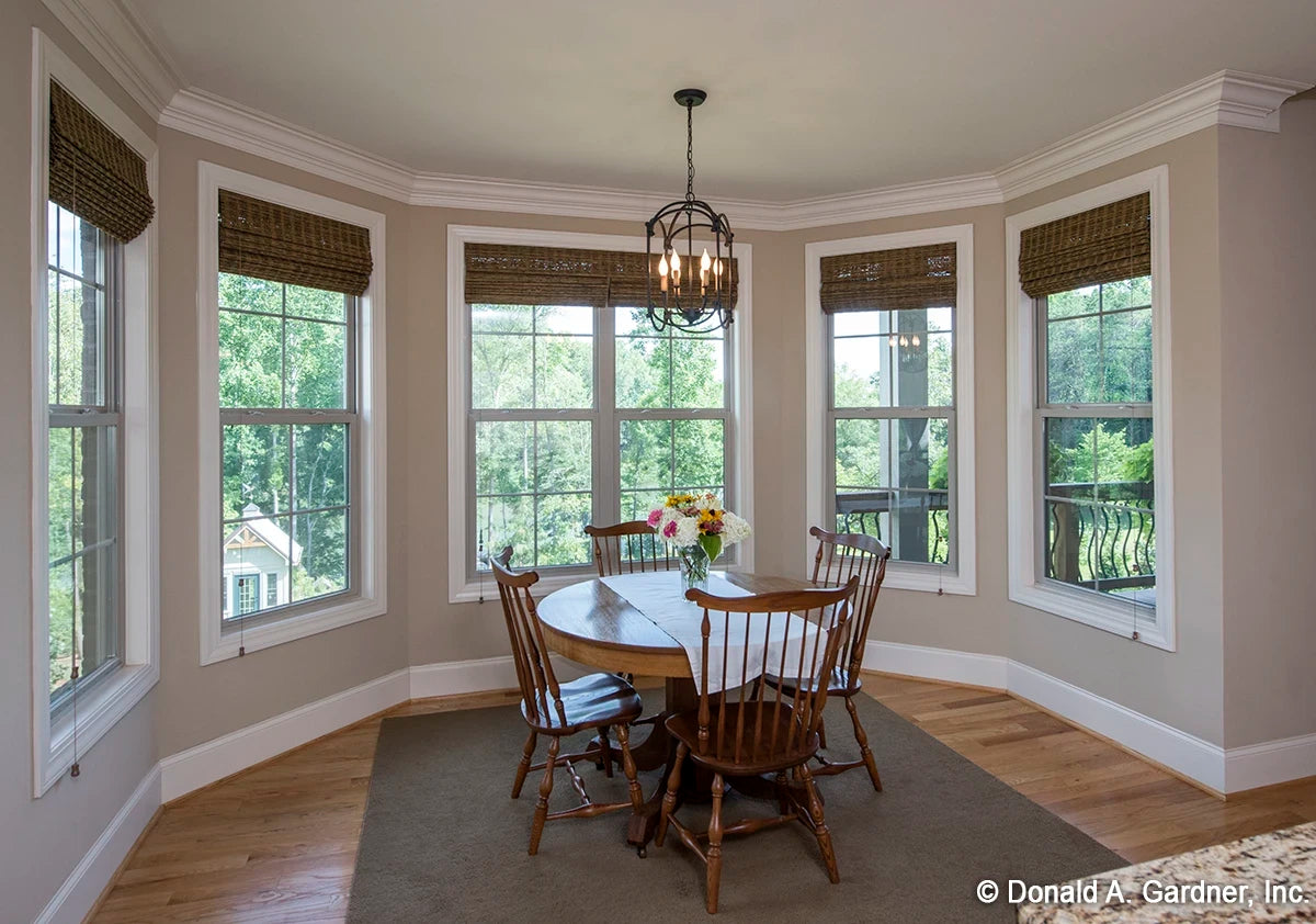 Breakfast nook area is surrounded by windows and features crown moulding.