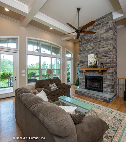 Great room with coffered ceilings, a fireplace and access to the large rear porch