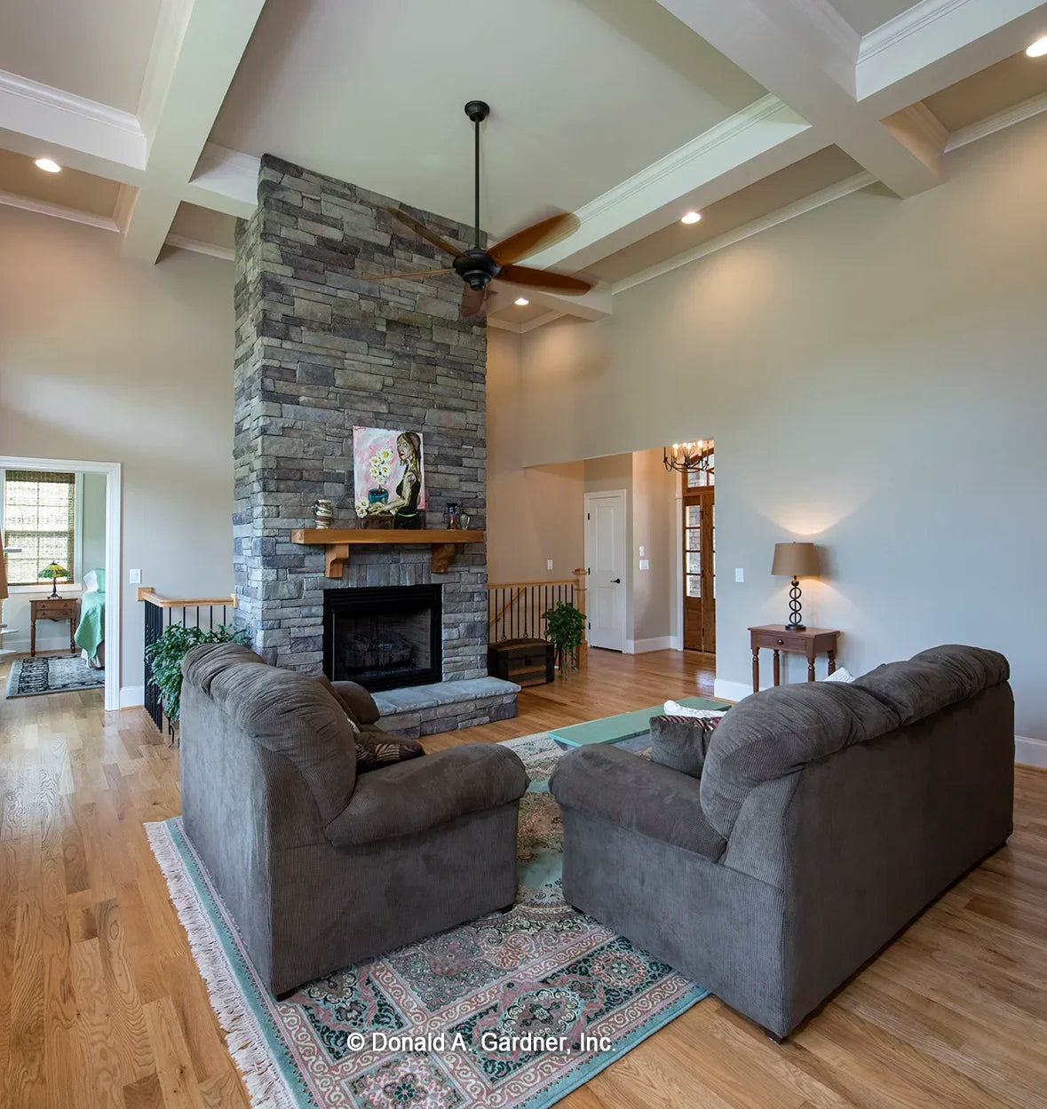 Great room with a view of the foyer and front door with stairs to the basement behind the fireplace