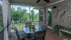 Screened porch has crown molding, tongue and groove ceiling and a welcome ceiling fan 