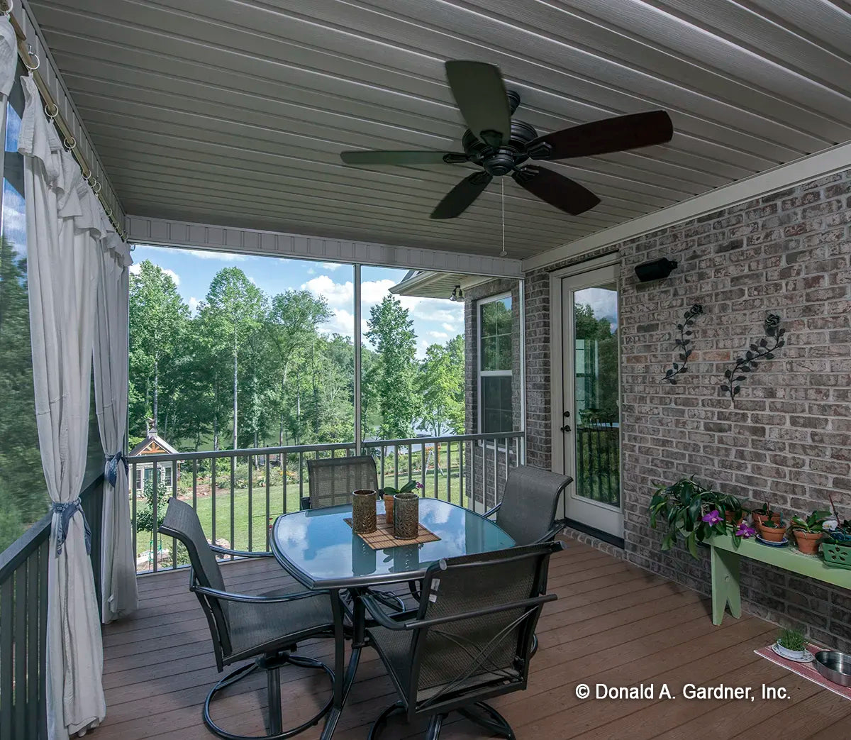 Screened porch has crown molding, tongue and groove ceiling and a welcome ceiling fan 