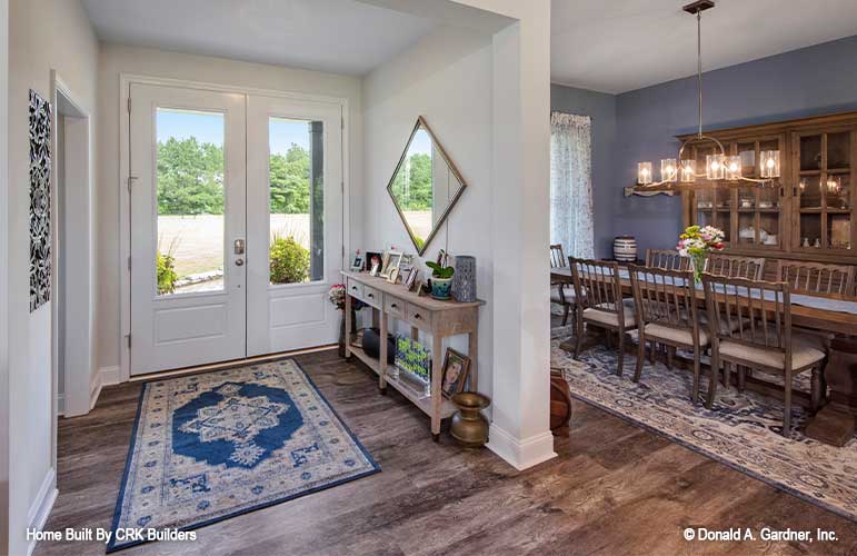 Foyer with double glass front door and peak of dining room off to the side. Sloan plan 1528