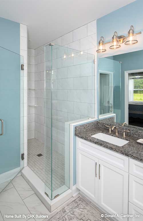 Opposite of the vanity is a tiled walk-in shower. Sloan plan 1528