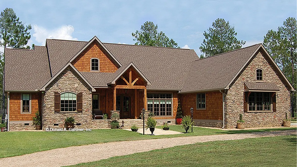 Photographs submitted by the customer. Front view of a stone and cedar craftsman style home. The Sycamore Hall plan 5000.