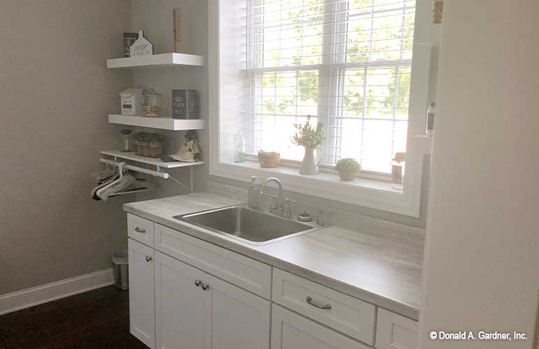 Countertop space and utility sink with spacious shelving make this utility room very functional of The Sydney plan 1438