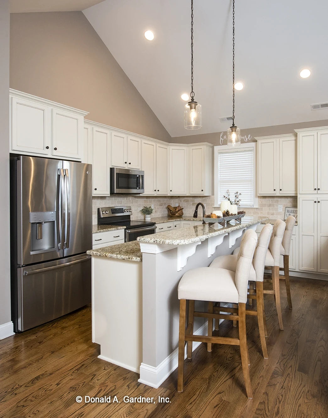 Open floor plan show kitchen sharing the vaulted ceiling of the great room