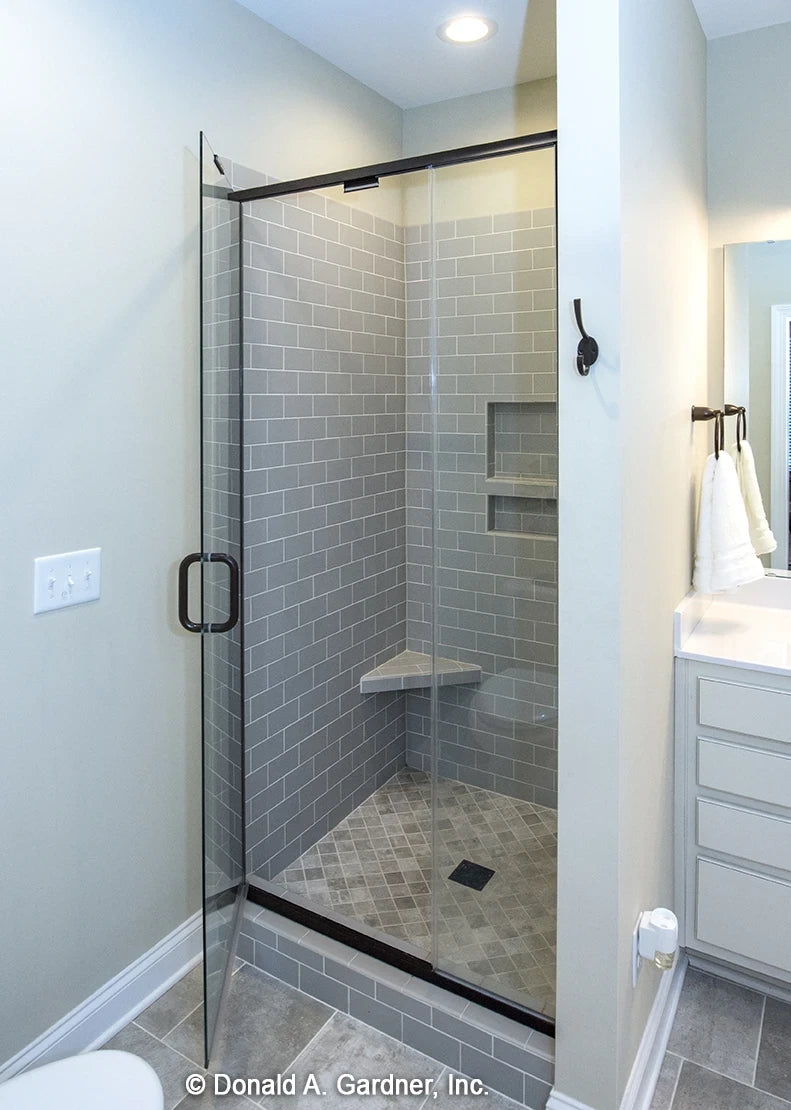 Mater bath walk-in shower with built-in shelves and a corner bench