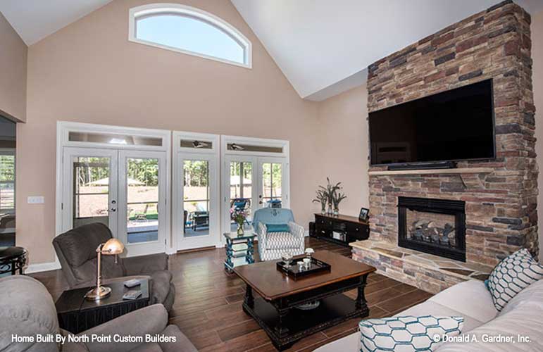 Floor to ceiling stone fireplace and arch window in the great room. The Travis plan 1350.