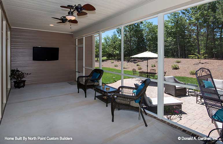 Screened in porch with tv and ceiling fan. The Travis plan 1350.